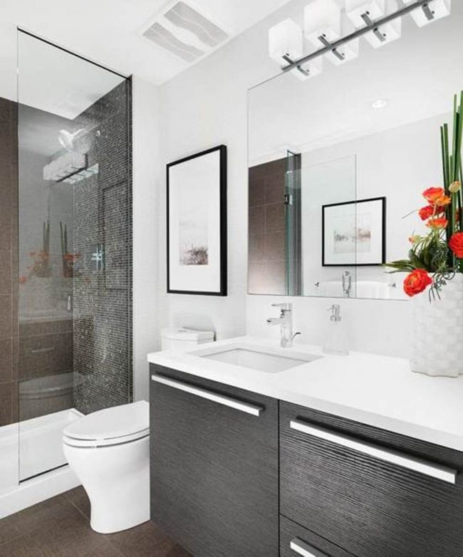 Les petites salles de bains sont agrandies par de grands miroirs, des murs blancs et des parois de douche transparentes.