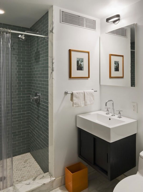 Élégant lavabo en céramique blanche avec, en dessous, un meuble-lavabo brun foncé. Murs blancs et douche en gris foncé. 