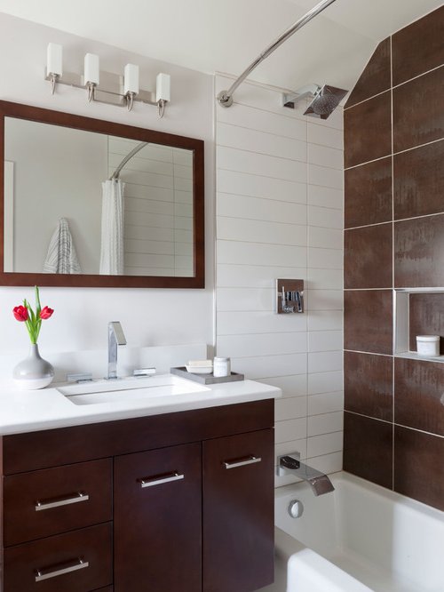 Salle de bains avec murs et plafond blancs, paroi de douche en brun foncé pour créer de la profondeur.