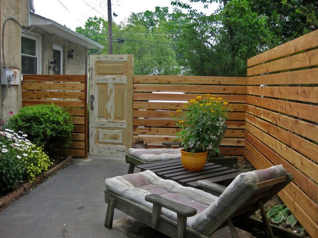 jardin avec hautes clôtures en bois et fauteuils confortables